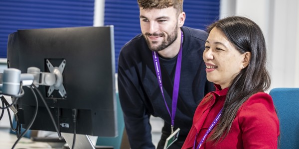 Finance employees working together at laptop